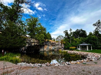 Indian Springs waterfall and pond with gravel walking trail and gazebo. Located in Spearfish, South Dakota.