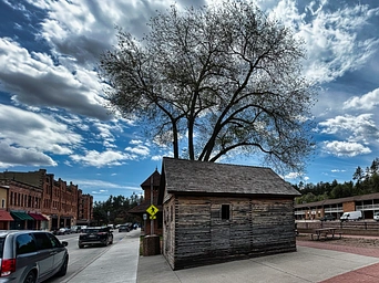 Historic 1888 Hot Springs, SD Jail on River Street. Sandstone buildings in the background.