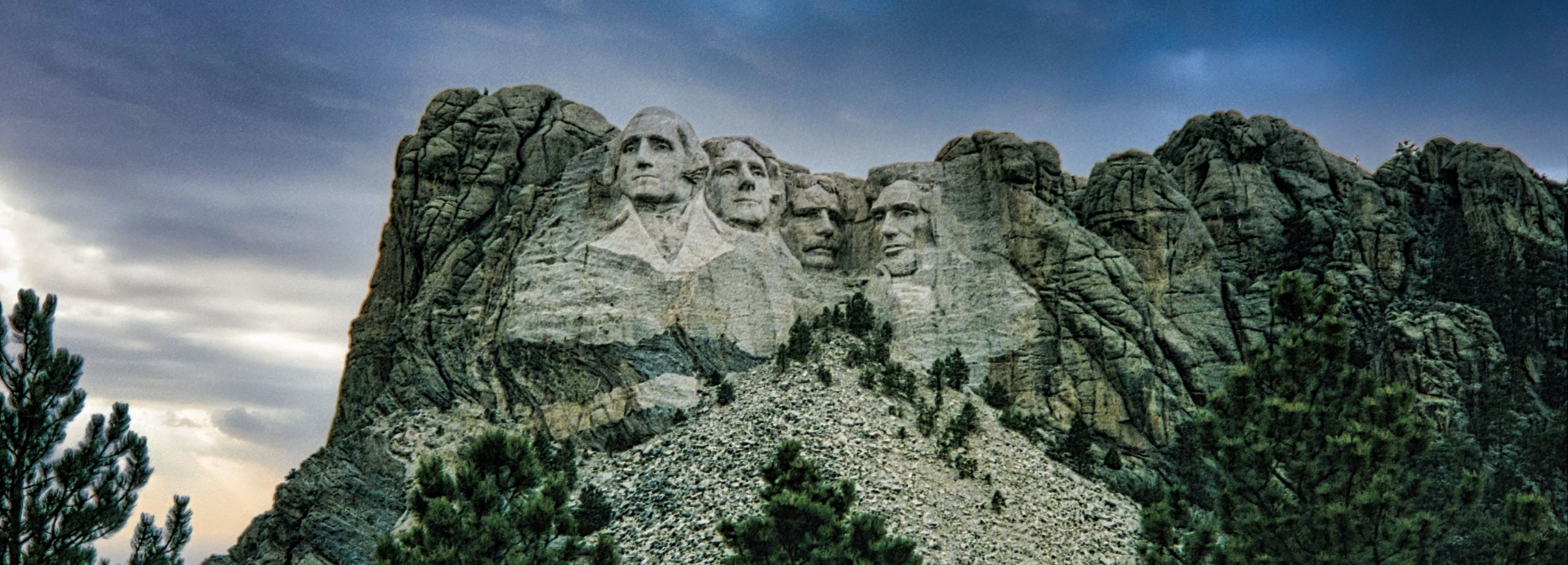 Mount Rushmore in South Dakota in the evening with clouds overhead.