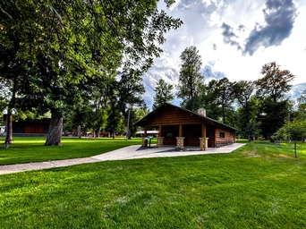 The historic city building at Spearfish City Park with an amphitheater on the left and a playground in the background.
