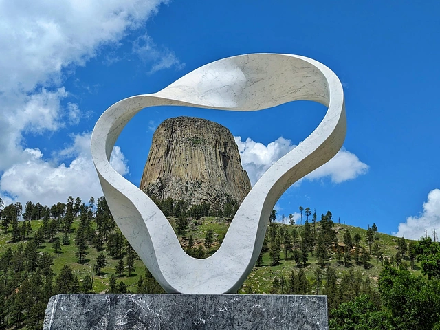 12' white marble Wind Circle Sculpture framing Devils Tower in the distance.