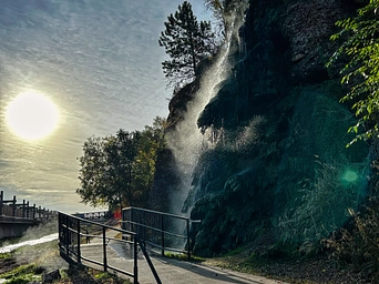 Fall River waterfall along the Freedom Trail in Hot Springs, SD. Sun shines through the clouds.