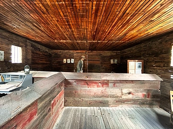 Inside the 1888 historic jail in Hot Springs, SD. Informational sign and mannequin.