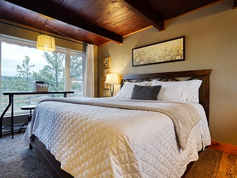 King bed in luxury cabin rental in Hot Springs, SD - white poppy print above the bed.