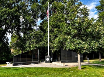 Granite slabs with soldier information at the Veteran's Memorial across from Spearfish City Park in SD. American flag in middle.