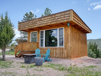 Cabin rental in Hot Springs, SD wit private fire pit and Adirondacks in the middle of Highland Meadows Resort.