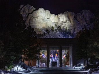 Mount Rushmore with faces lit up at night lighting ceremony.
