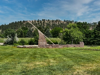 A giant stone sundial in William Nordemeer Formal Gardens in Sioux Park, Rapid City. Black Hills in the distance.