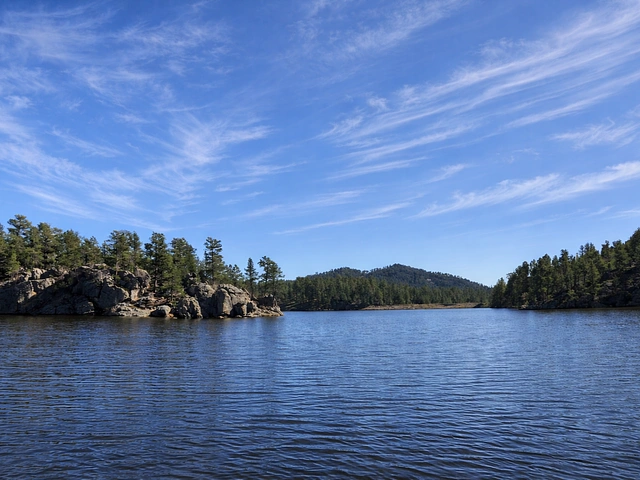 Bismark Lake near Nemo, SD for fishing under clear skies against a rocky backdrop and Ponderosa pines.
