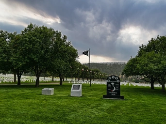 The Vietnam memorial stone at the Fort Meade National Cemetery near Spearfish, SD. Flags and headstones in background.