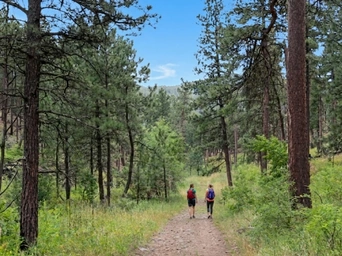 Two women hiking the Spring Creek Trail / Sheridan Lake Shore Trail in the Black Hills of South Dakota.