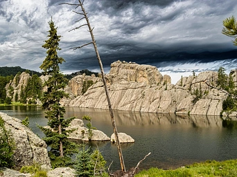 Rocks at Sylvan Lake with stormy skies and reflections in the water - Custer State Park.
