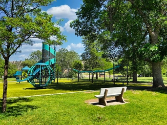 The playground at Sioux Park. Climbing structures and park benches.