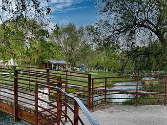 Bridge over Fall River - mineral fed water - with Brookside Park in the distance. Hot Springs, South Dakota.
