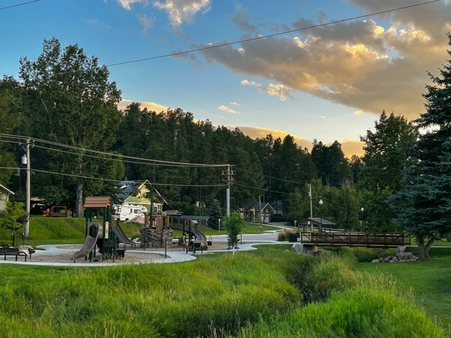 Harbach Park in Custer, South Dakota. Playground and bridge or a winding river with natural grasses.