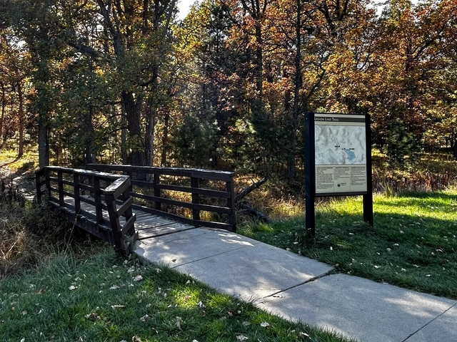 Legion Lake trailhead with trail map sign beside a bridge. In Custer State Park in South Dakota.