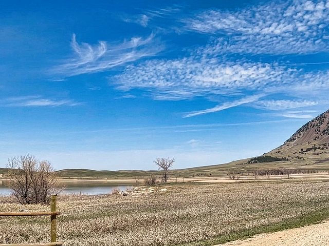 Bear Butte Lake in South Dakota. Blue skies and wispy clouds overhead.