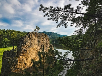 Rock outcropping next to a green meadow at Lakota Lake in Custer State Park, SD
