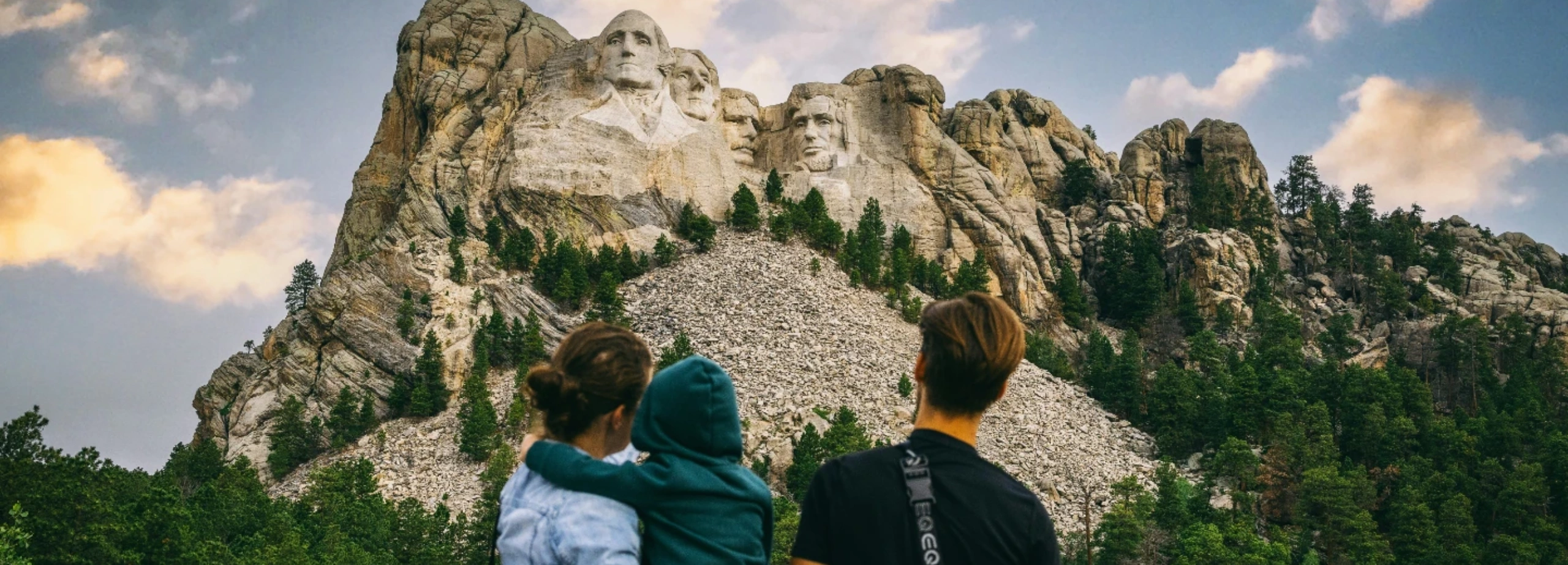 Family visiting Mount Rushmore on vacation in the Black Hills - mom, dad, and child.