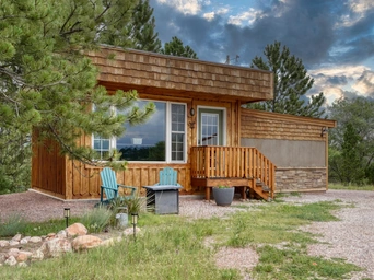 Exterior of Ponderosa Cabin with private fire pit and pines at Highland Meadows Resort in Hot Springs, SD.