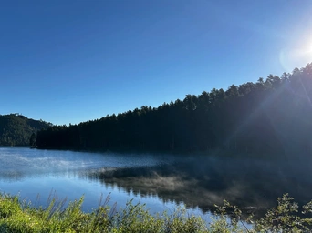 Steam rising from Sheridan Lake early in the morning. Views of the Black Hills near Hill City, SD.