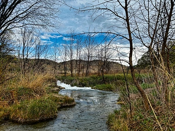 Cascade Springs natural mineral springs flowing into a river. Fall foliage in South Dakota.